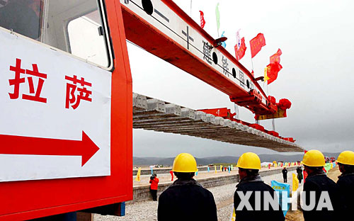 西藏境內(nèi)第一段鐵路軌排在安多火車站鋪下,鐵軌將從這里向拉薩繼續(xù)延伸(2004年6月22日攝)。 青藏鐵路從西寧至拉薩全長(zhǎng)1956公里,是世界上海拔最高、線路最長(zhǎng)、穿越凍土里程最長(zhǎng)的高原鐵路。把鐵路修進(jìn)西藏是幾代中國(guó)人的夢(mèng)想,但這一想法直到新中國(guó)成立后才逐漸變?yōu)楝F(xiàn)實(shí)。青藏鐵路一期工程西寧至格爾木段于1958年開工,1984年交付營(yíng)運(yùn)。但限于當(dāng)時(shí)國(guó)家的經(jīng)濟(jì)實(shí)力以及高原、凍土等筑路技術(shù)難題尚未解決,格爾木至拉薩段被迫停建。2001年6月,國(guó)家總投資330.9億元?jiǎng)庸ば藿ㄇ嗖罔F路二期工程。這一工程跨越昆侖山、唐古拉山,通過(guò)多年凍土層和大片“生命禁區(qū)”,是人類鐵路建設(shè)史上亙古未有的穿越。它的建成將為神秘而古老的青藏高原帶來(lái)新的生機(jī)和活力! 新華社發(fā)